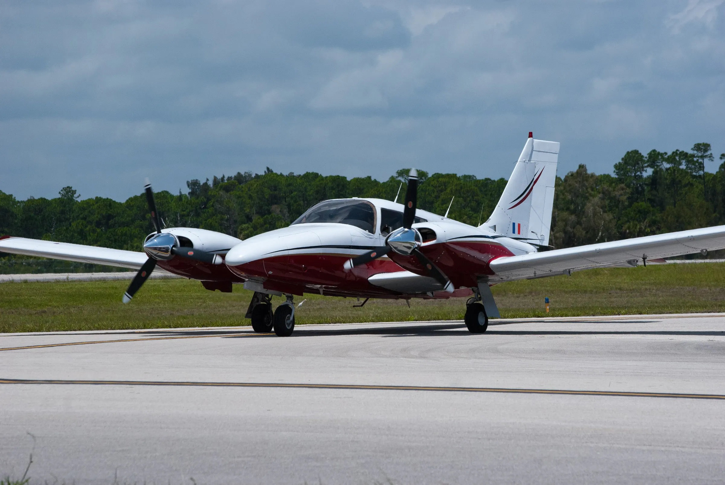 White and burgundy Piper Seneca III on the taxiway, front three-quarter view